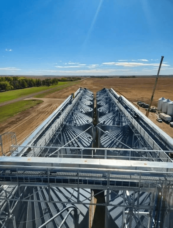 Galvanized RapiTruss catwalk with handrails running over a row of hopper bins