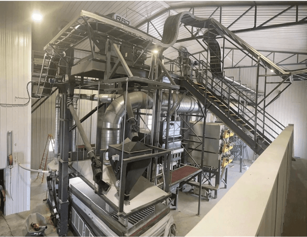 Seed processing plant interior with cleaning equipment, platforms and stairs